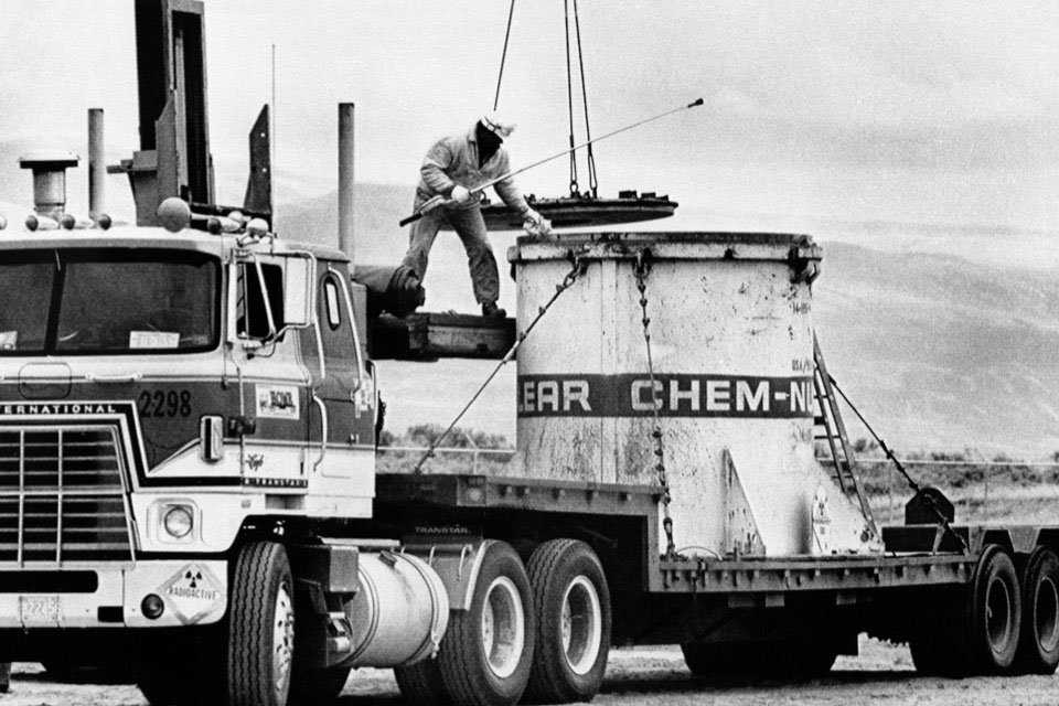 Stacks of 50-gallon drums and fiberglass-covered boxes containing radioactive waste (mostly low-level, long-lived plutonium) sat in the storage area at the National Reactor Testing Station in Idaho, circa 1974.