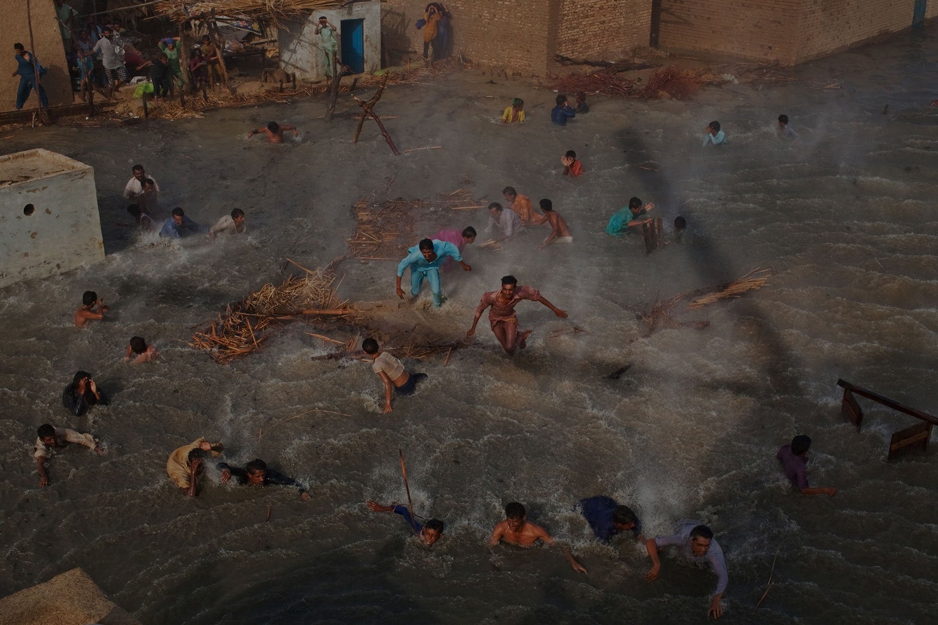 Flood victims scrambled for food rations as they battled the downwash from a Pakistan Army helicopter during relief operations in 2010, in the village of Goza in the Sindh province of Pakistan. The country's agricultural heartland was devastated, with rice, corn, and wheat crops destroyed by floods. The UN described the disaster as unprecedented, with over a third of the country underwater.